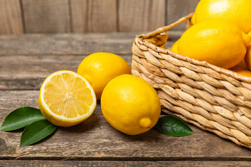 Lemon on a wooden table. Fresh lemon with a slice. Fresh lemon with citrus leaves. Lemon juice. Food and drink ingredients preparing. Healthy eating. Vitamin C. Space for text.