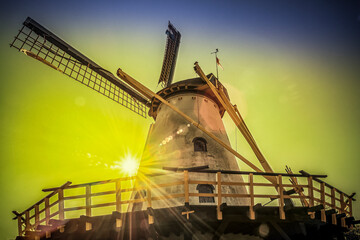 Historic Dutch windmill with sun lens flare at sunset