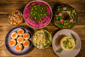 Tartlets with red caviar and festive salads on a wooden table. Festive food