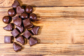 Heap of chocolate candies on a wooden table