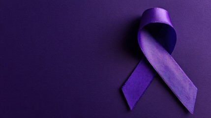 A close-up shot of a purple ribbon, symbol for awareness, resting against a dark background, shadows are visible, highlighting its textured surface
