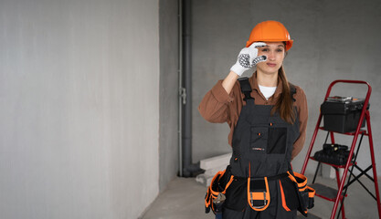 Woman Builder. Female Architect pointing fingers gesture small measure size in unfinished building....