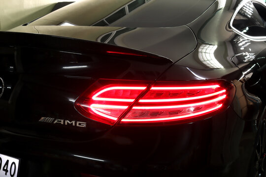 nice design led tail light or tail lamp of black sports car brand Mercedes Benz c200 AMG coupe model park in the dark garage during checking and maintenance process