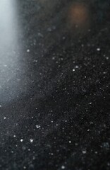 Obraz premium Black speckled granite surface for home decor. Dark textured material ideal for modern kitchen countertops bathroom vanities. Offers durability, sleek aesthetic suitable for interior design projects.