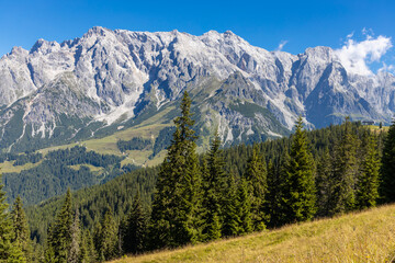 Fototapeta premium Hochkonig mountain range in Austria. Alps mountains on a sunny day. Mountain landscape. Blue sky with some clouds above beautiful summits alpine range Hochkonig in Austria Tyrol