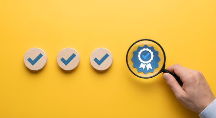 magnifying glass on wooden checkmarks and quality stamp