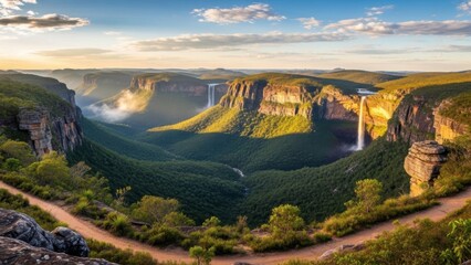 A breathtaking landscape of a valley with waterfalls and a winding dirt road at sunrise