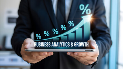 Businessperson holding tablet with rising bar chart labeled “BUSINESS ANALYTICS & GROWTH