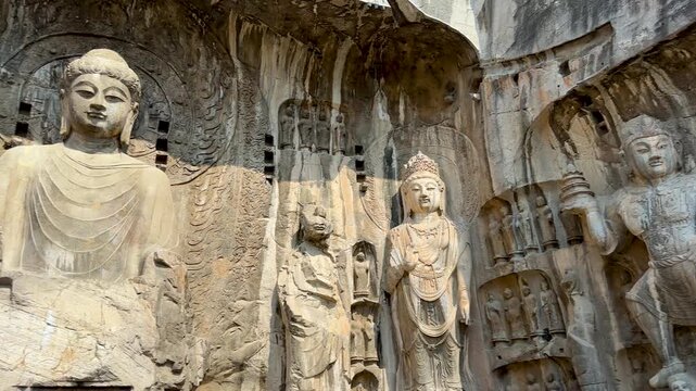 Statues of Vairocana Buddha modeled after Empress Wu Zetian, disciples, Bodhisattvas, Heavenly Kings, Warriors in Fengxian Temple Cave at Longmen Grottoes, Luoyang, Henan, China. UNESCO World Heritage