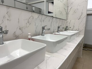 Fototapeta premium Modern Bathroom Sink with Marble Tiles Close-Up