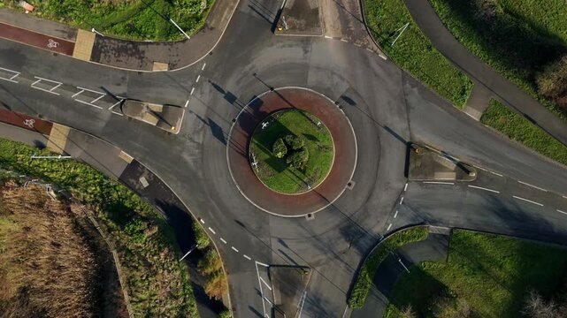 Top down aerial view of cars driving around roundabout in Ely, United Kingdom. Afternoon winter light.