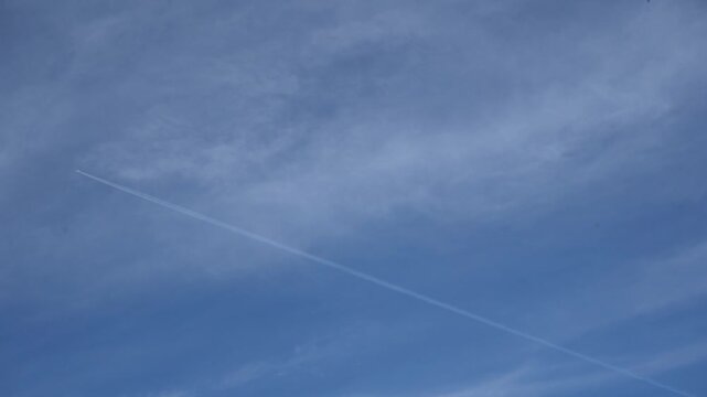 Avion dans le ciel laissant des tra&icirc;n&eacute;es blanches au ralenti