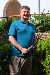 Adult Man Pruning Bushes in His Garden with Shears, Enjoying Productive Day at Home Surrounded by Lush Greenery and Nature.
