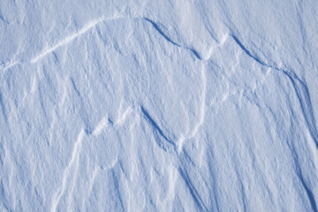 Natural snow background with drawings of mountains made by the wind