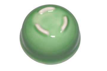 A close-up shot of a green object sitting on a white surface, providing high contrast and making the object stand out