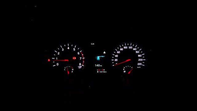 Nighttime driving scene features a glowing car dashboard with analog gauges and a digital screen, representing automotive technology and road travel.