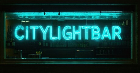 Obraz premium Bright neon sign spells CITYLIGHTBAR. Interior dimly lit, bottles visible behind bar. Nighttime scene, urban aesthetic.