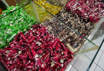 Pile of sweet green toffee called "Dodol Garut" in clear plastic wrappers. A famous Indonesian souvenir from Garut, West Java,  with a sticky texture and modern colorful look.