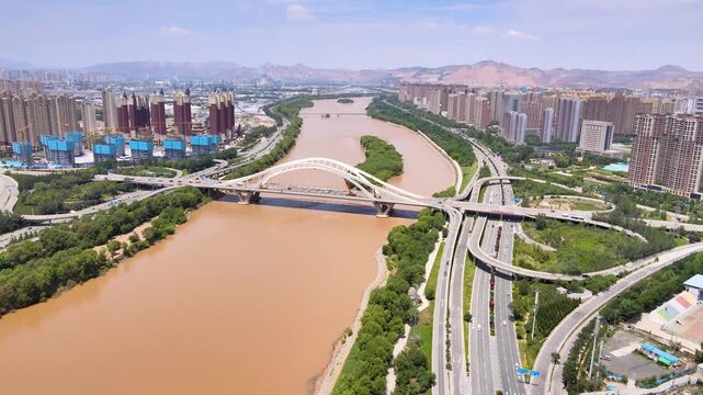 Aerial View of Yellow River and Modern Bridge in Lanzhou City, China with Urban Skyline and Mountains