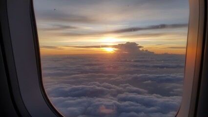 Sunset Above the Clouds from an Airplane Window