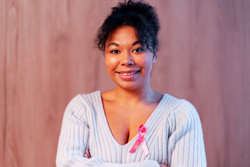 Fototapeta premium Woman smiling, wearing pink ribbon for breast cancer awareness, fostering hope