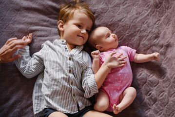 Older Brother Lying With Newborn Sister