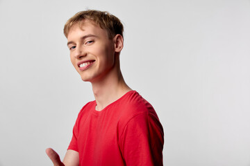 Smiling man in a red shirt with casual style and bright studio lighting conveys a friendly, approachable vibe suitable for lifestyle, youth, and marketing campaigns