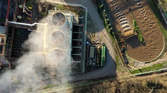 Top down aerial view of industrial cooling fans and smoke plumes with cooling water recirculation from sugar processing and production in Wissington, United Kingdom 