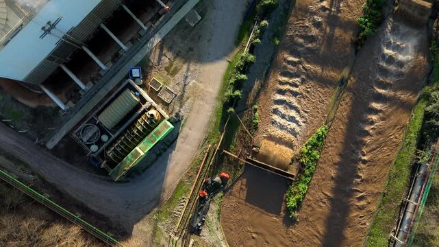 Top down aerial view of industrial cooling fans and smoke plumes with cooling water recirculation from sugar processing and production in Wissington, United Kingdom 