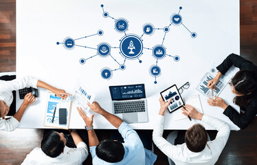 A diverse team engages in a strategic meeting, utilizing technology and data analysis tools to drive innovation and collaboration in a modern business environment. Amity