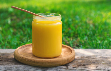 Ghee in a jar in a meadow. Selective focus.