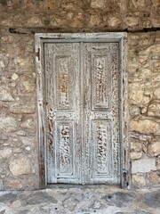 Weathered wooden door on ancient stone wall showcasing rustic textures and historical background