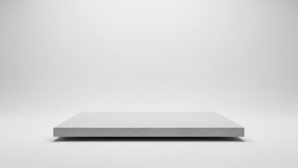 A white, empty stage with a concrete floor.