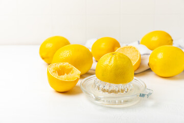 Lemon juice. Fresh lemon juice in a bowl. Ripe citrus, mint, fruit, and a juicer on the table. Vitamin C. Lemon water. Ingredient for baking or salad dressing. Space for text. Copy space.