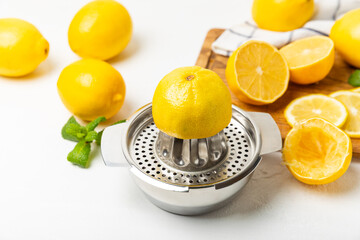 Lemon juice. Fresh lemon juice in a bowl. Ripe citrus, mint, fruit, and a juicer on the table. Vitamin C. Lemon water. Ingredient for baking or salad dressing. Space for text. Copy space.