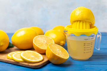 Lemon juice. Fresh lemon juice in a bowl. Ripe citrus, mint, fruit, and a juicer on the table. Vitamin C. Lemon water. Ingredient for baking or salad dressing. Space for text. Copy space.