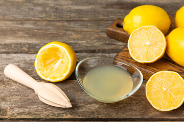 Lemon juice. Fresh lemon juice in a bowl. Ripe citrus, mint, fruit, and a juicer on the table. Vitamin C. Lemon water. Ingredient for baking or salad dressing. Space for text. Copy space.
