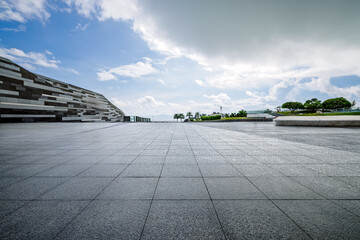 Empty square floor and modern architecture with blue sky background.