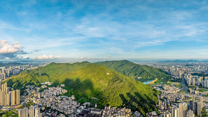 Aerial view of the green mountains and city residential buildings in Zhuhai.