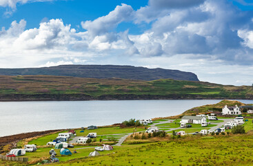 Coastal campsite with caravans beside bay in Scottish Highlands