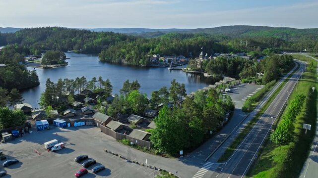 Drone view of Abra Havn and surrounding lakes Kristiansand. Elevated aerial perspective capturing pirate village waterways and forested landscape during calm summer conditions.