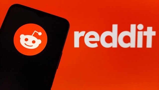 Reddit logo on a smartphone screen with orange background