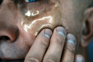 man applying anti-age patch