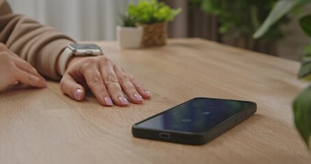 A woman hand activates the smartphone search function on a smartwatch by swiping the watch touchscreen. Modern technology and gadget protection. - Powered by Adobe