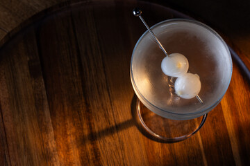 Ice cold Gibson Martini on a bar drop with dramatic shadows and warm tones