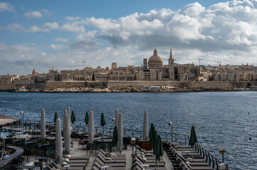 Coastline of Sliema and Tign&eacute; Point with boats, water, high-rise apartment buildings and a busy holiday atmosphere, illustrating lively Mediterranean coastal life Sliema, Malta, 9 DEC 2025.