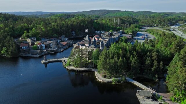 Aerial view of Abra Havn harbor buildings and fortress walls. Drone footage highlighting pirate-style architecture, docks, and water channels on a clear summer day.