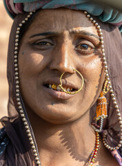 expressive face of indian woman daily wage worker at construction site in traditional attire