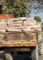 heavy sandstone slabs stacked on old truck for construction transport