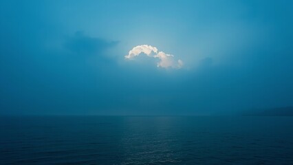 A serene ocean landscape with a single cloud in the sky